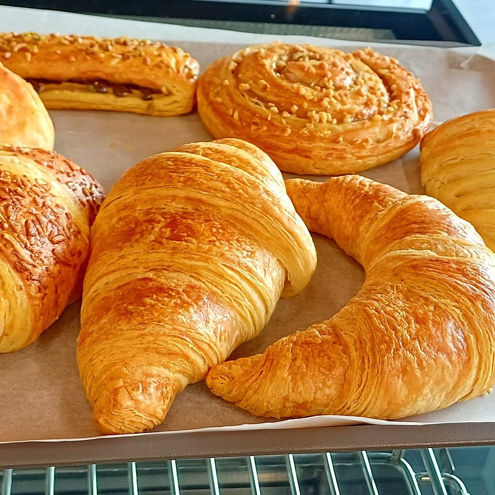Fresh croissants on a bakery tray
