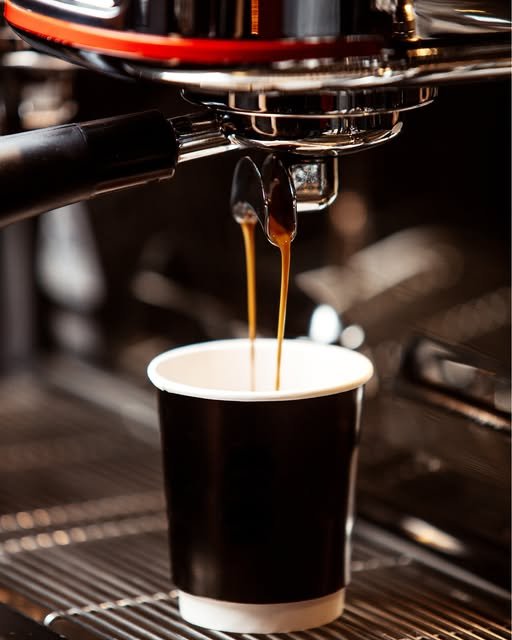 Espresso pulling into a black cup