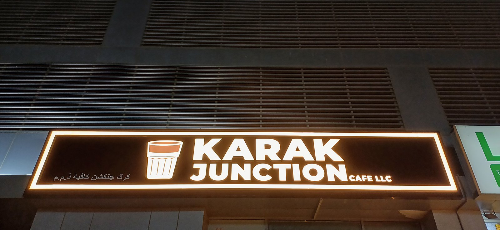 Karak Junction's illuminated sign glowing at night above the entrance, SkyCourt Tower B